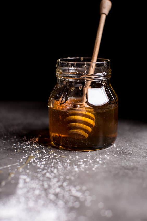 Honey dipper in a jar of honey.