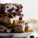 Lemon Blueberry Cheesecake Bars in a stack on a plate.