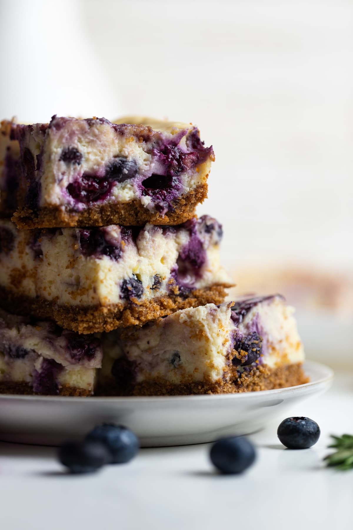 Lemon Blueberry Cheesecake Bars in a stack on a plate.