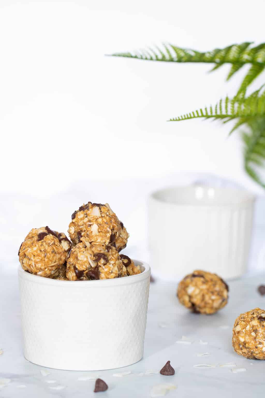 Chocolate Chip and Coconut No-Bake Energy Bites in a small bowl and on a counter.