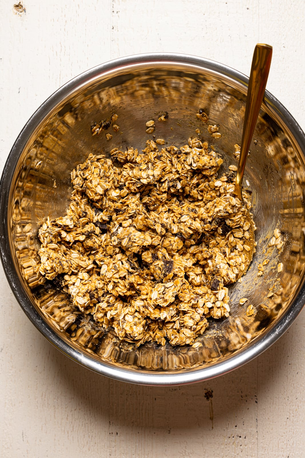 All ingredients mixed together in a large silver bowl with a spoon.