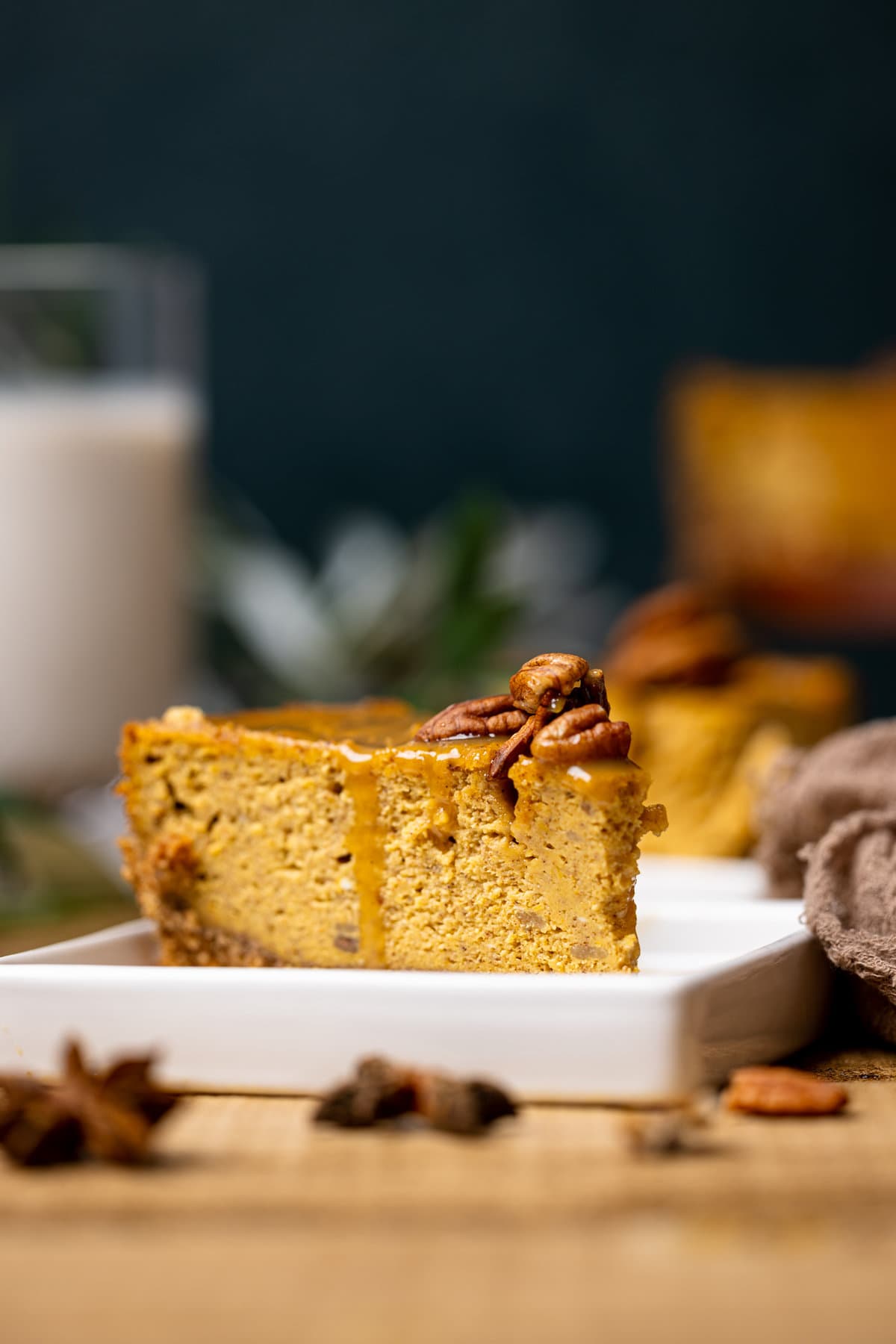 Slice of Caramel Pumpkin Cheesecake with a Pecan Crust on a plate