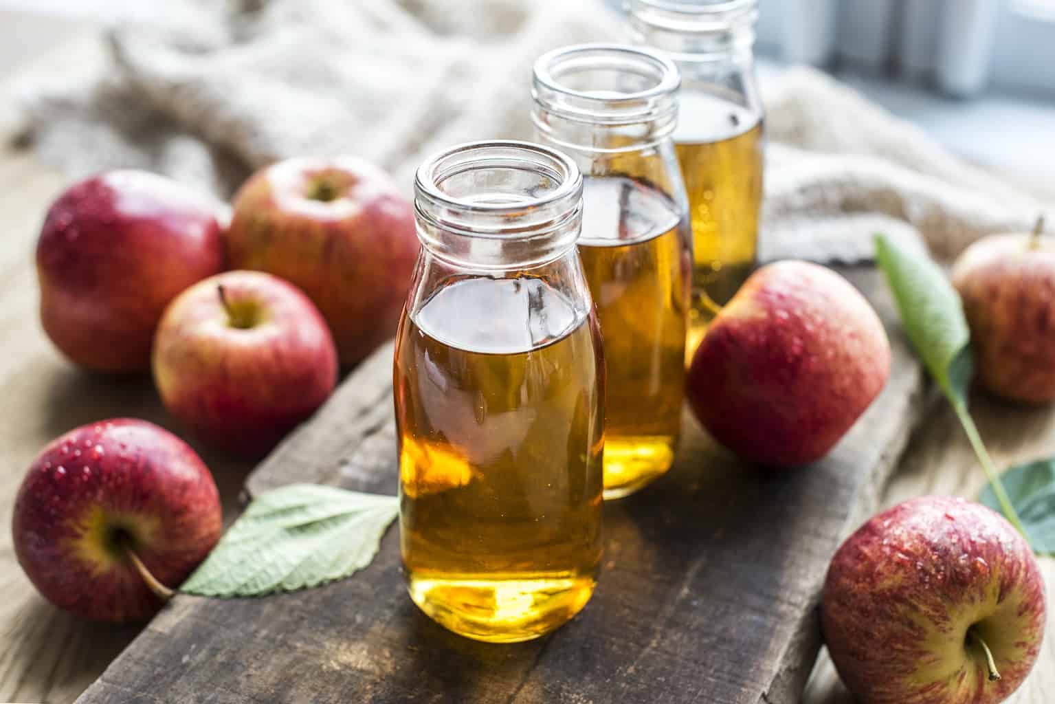 Three glass jars of apple cider.