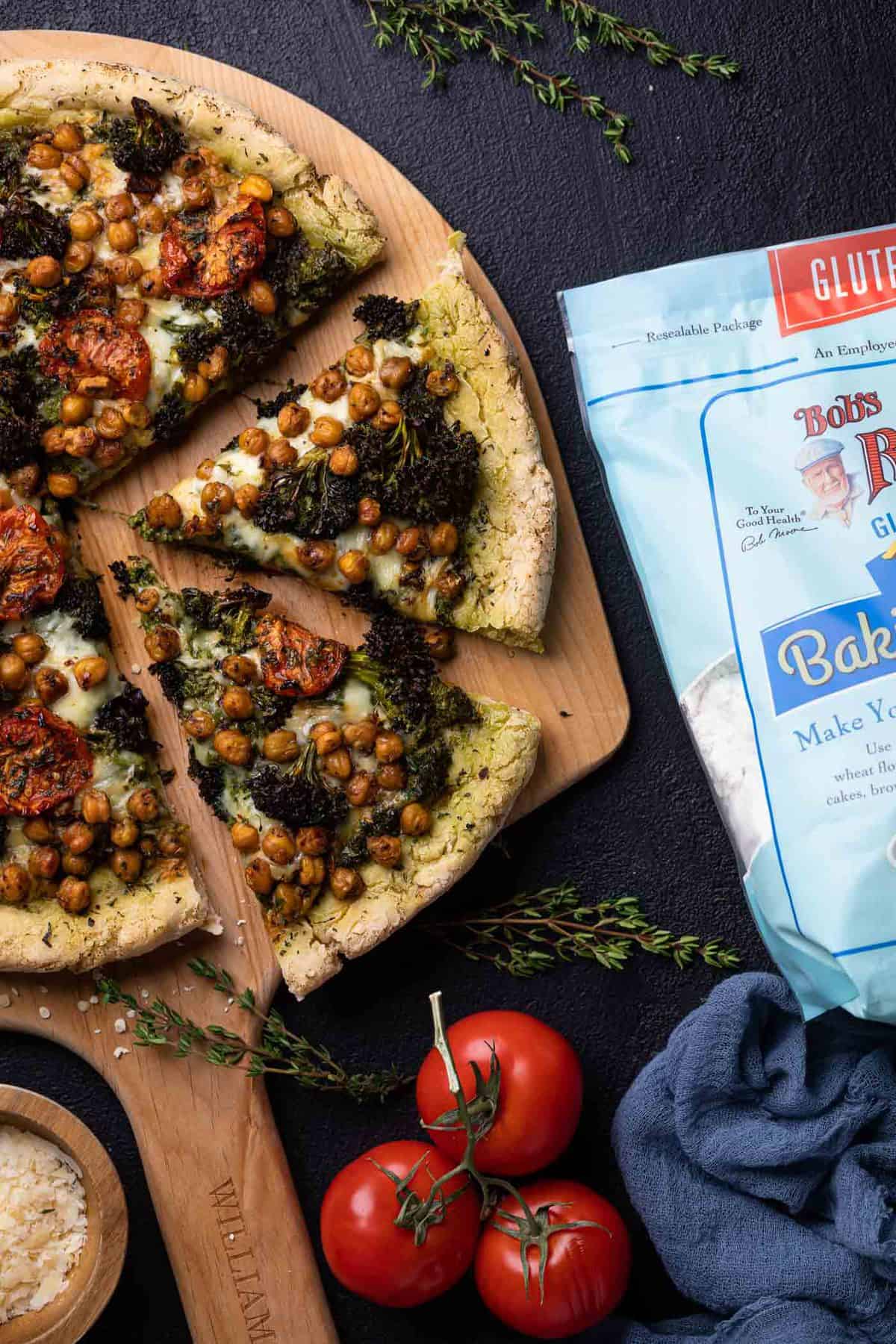 Slices of Chickpea amd Veggie Gluten-Free Pesto Pizza on a wooden board.