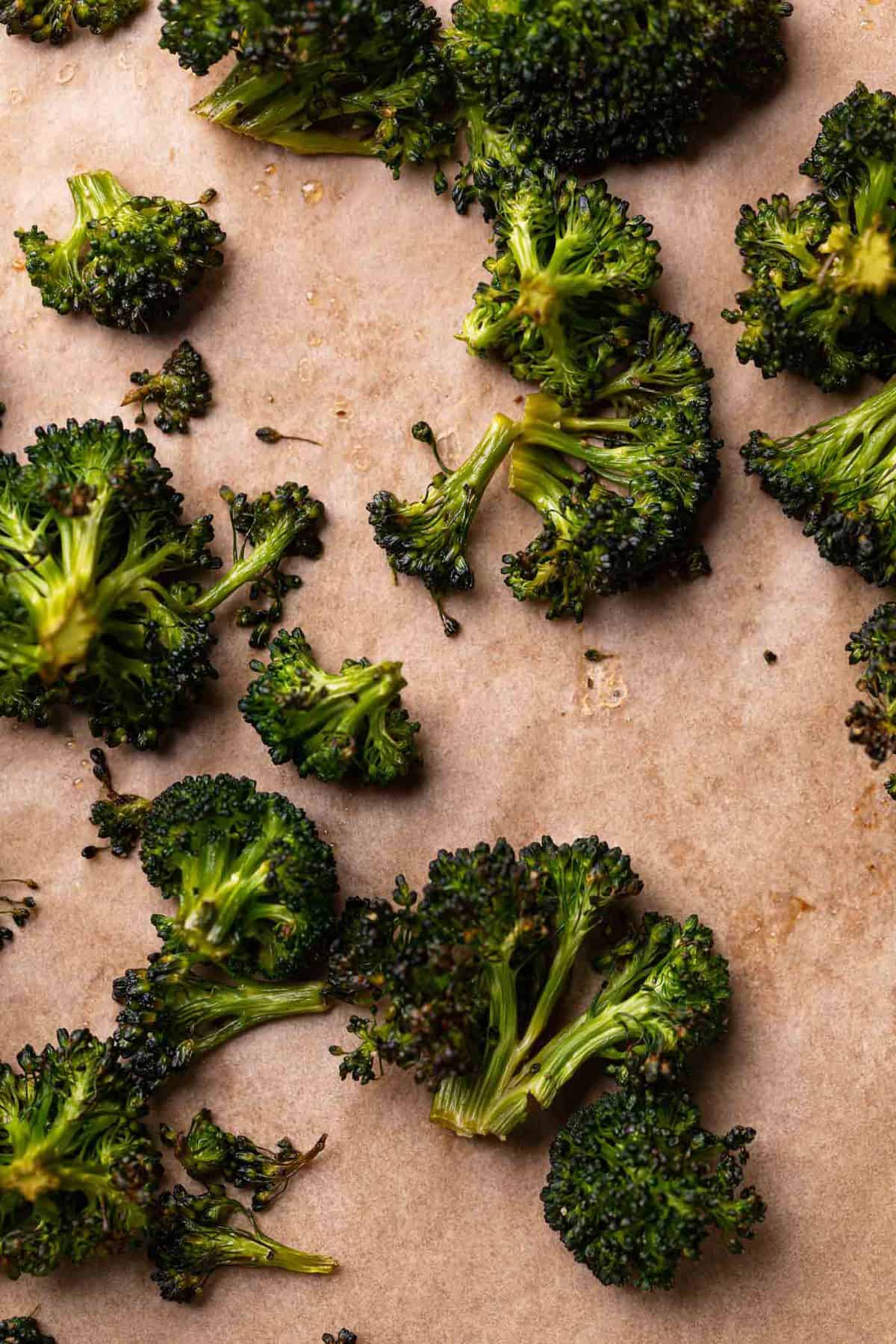 Roasted broccoli on parchment paper.