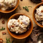 Up close shot of three bowls of ice cream with pecans and herbs.