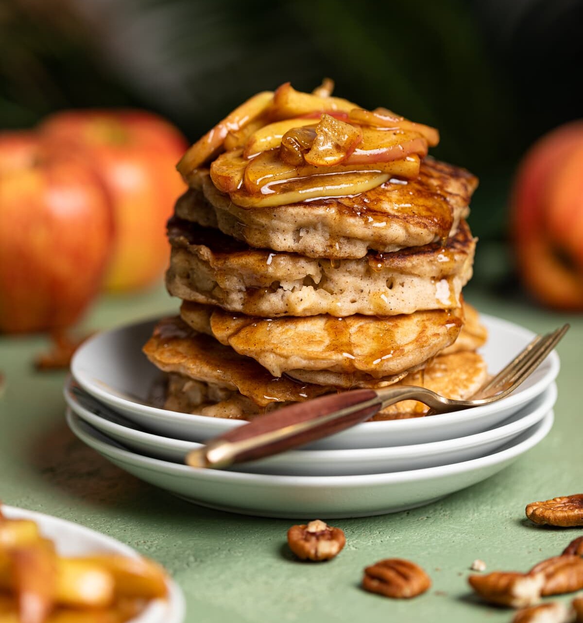 Stack of Vegan Apple Cinnamon Pancakes topped with caramelized apples and maple syrup