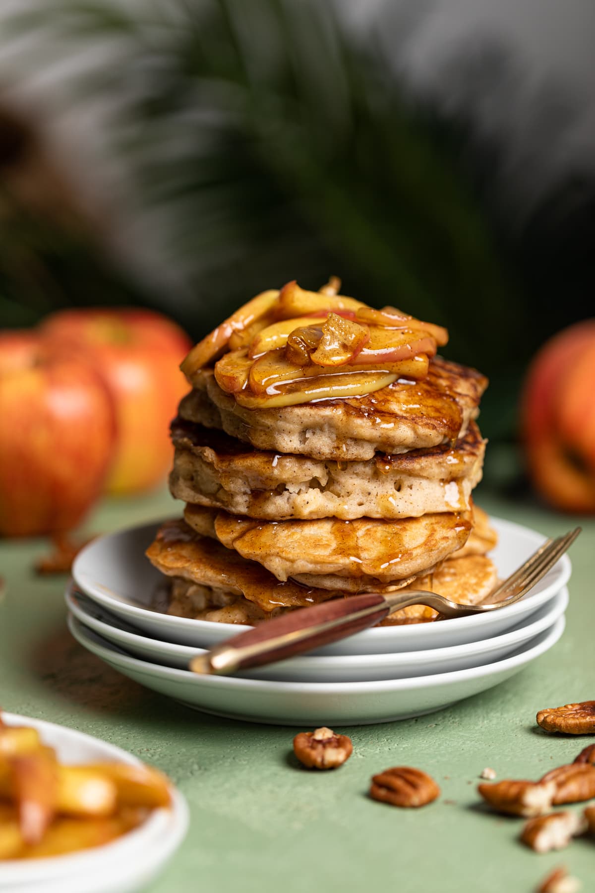 Stack of Vegan Apple Cinnamon Pancakes topped with caramelized apples and maple syrup