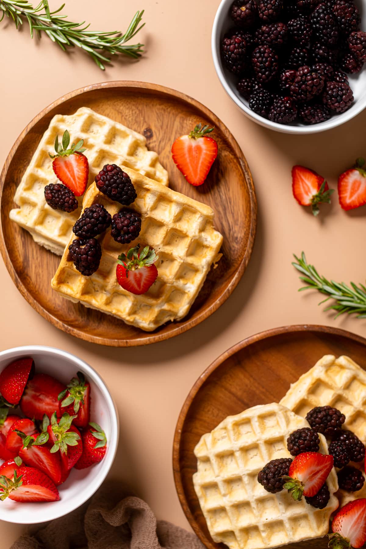 Wooden plates of Fluffy Cinnamon Vegan Belgian Waffles.