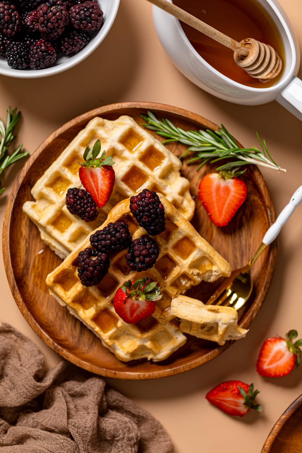 Fluffy Cinnamon Vegan Belgian Waffles on a plate with fruit.