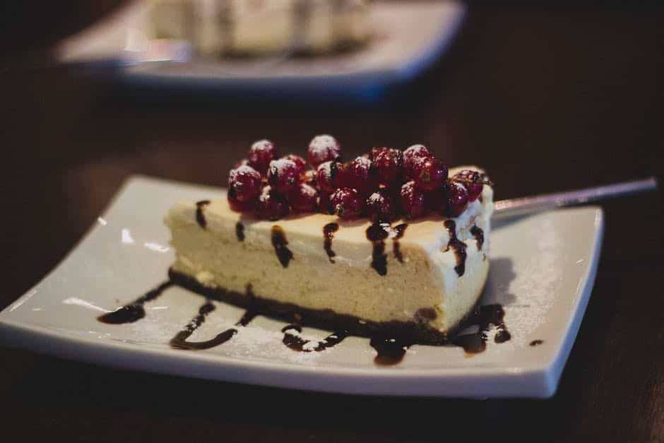 Slice of cake drizzled with chocolate on a white plate.