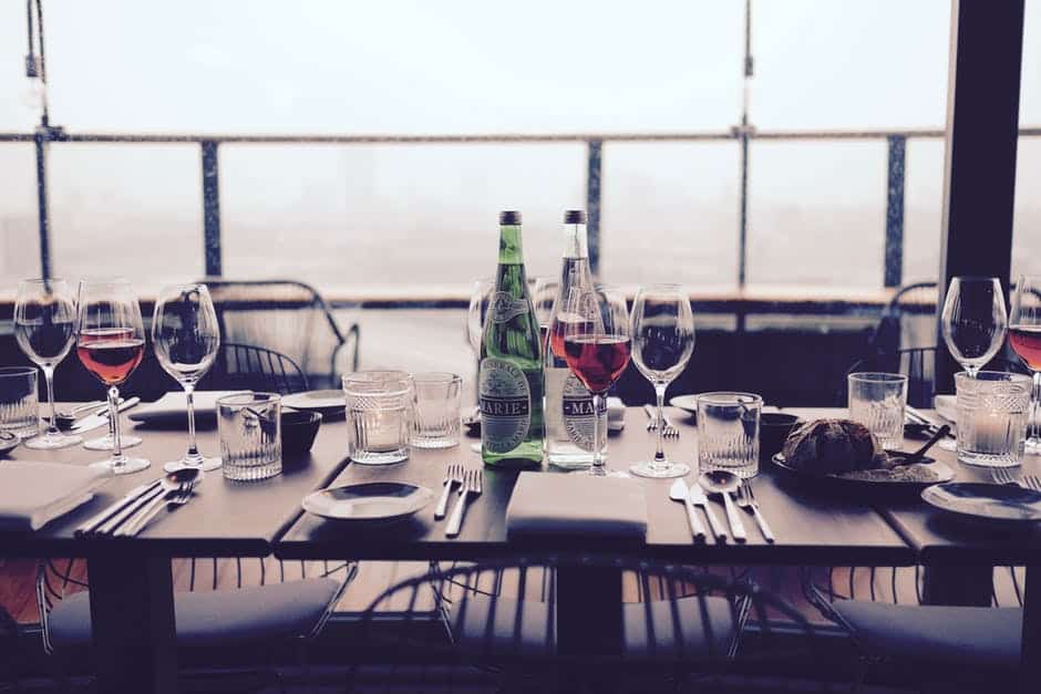 Table set with silverware, plates, and wine glasses.