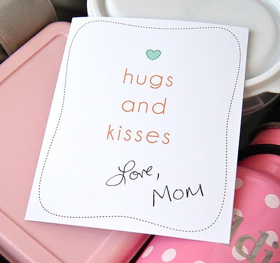 Paper that reads \"hugs and kisses Love, Mom.\"