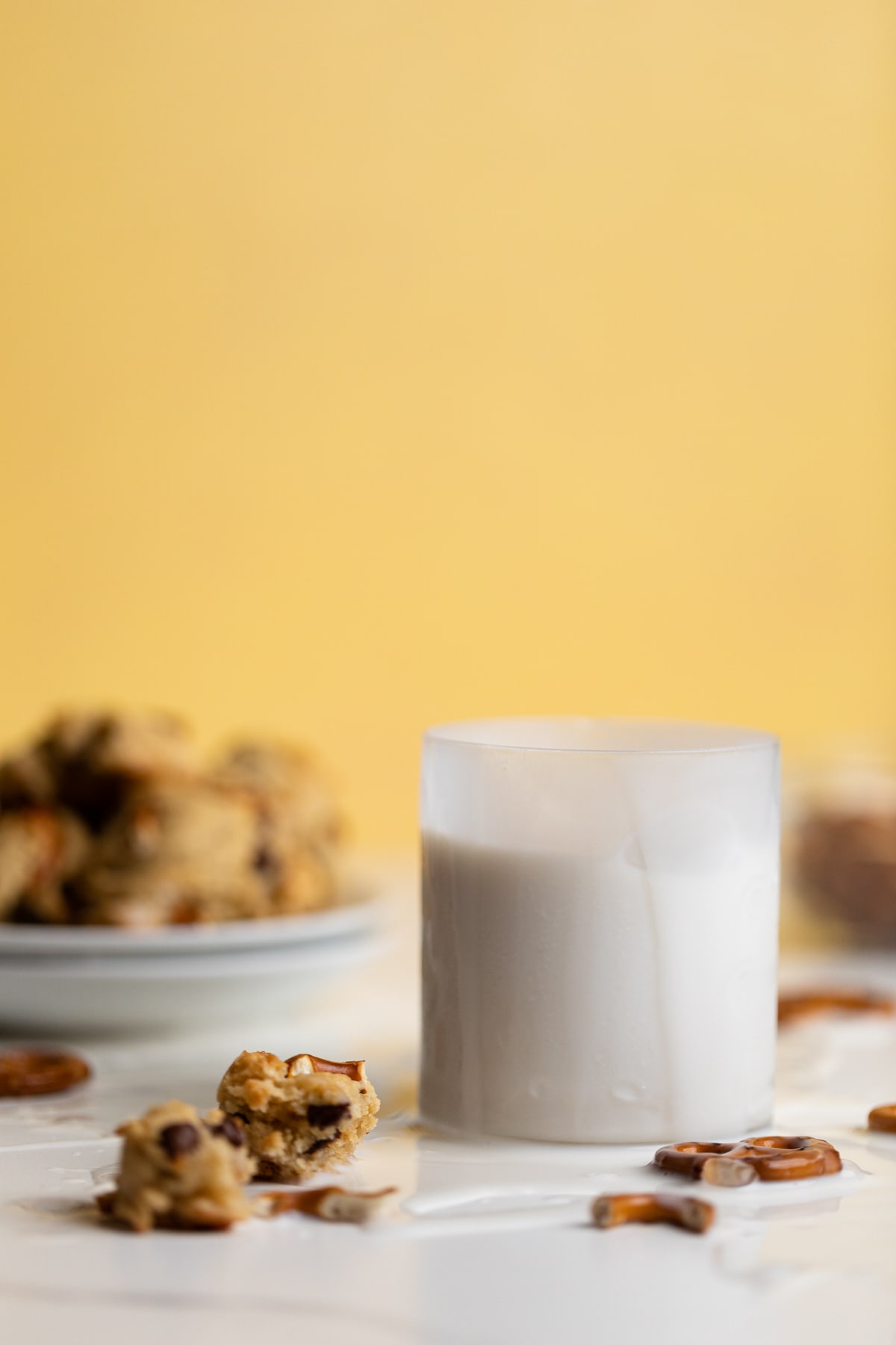 Glass of milk next to a puddle of milk.