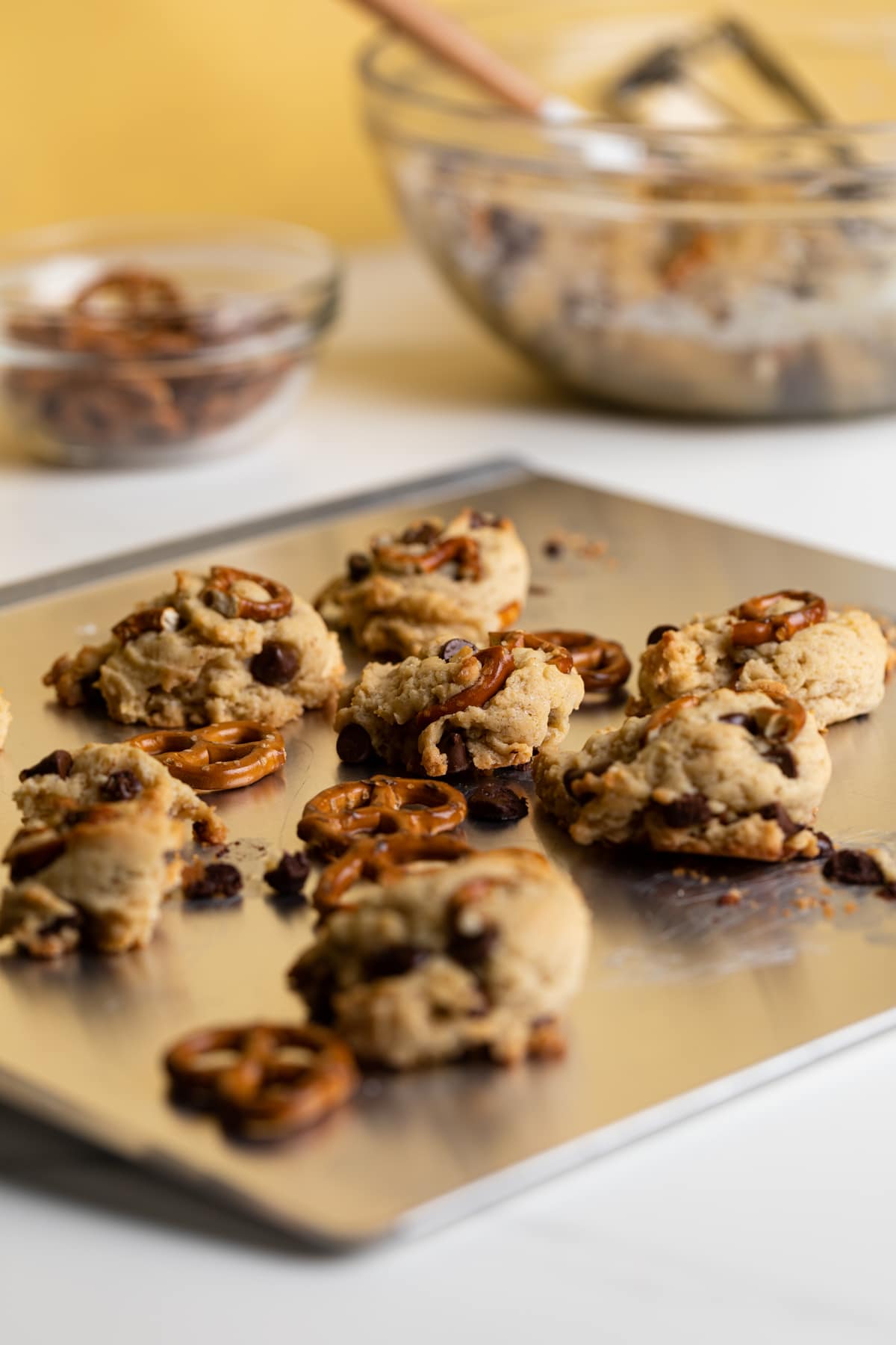 Chunky Vegan Chocolate Chip and Pretzel Cookies on a baking sheet.