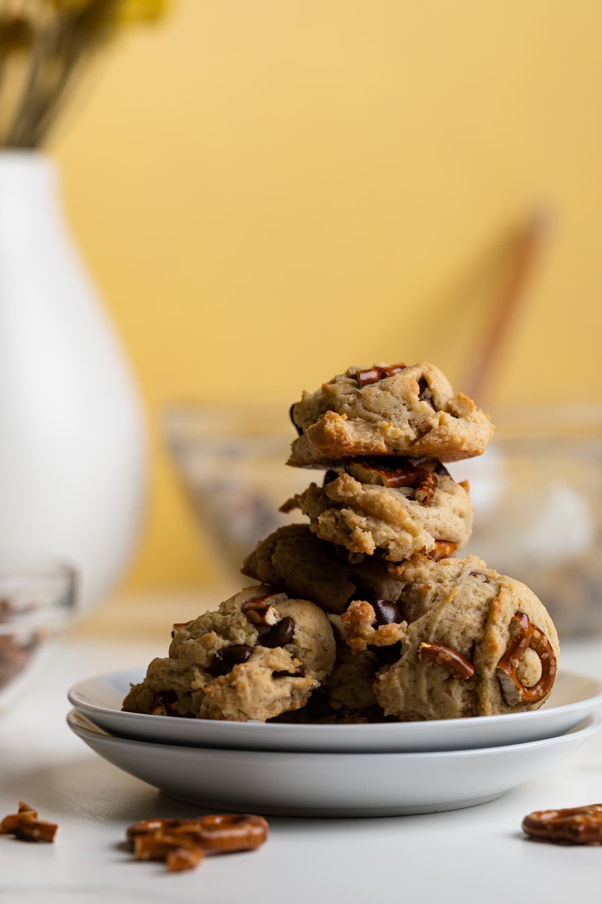 Chunky Vegan Chocolate Chip and Pretzel Cookies piled high on small plates.