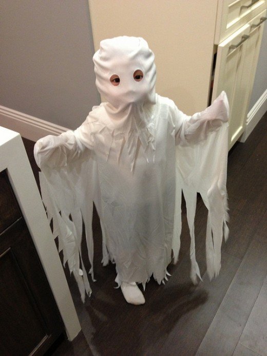 Child wearing a ghost costume.