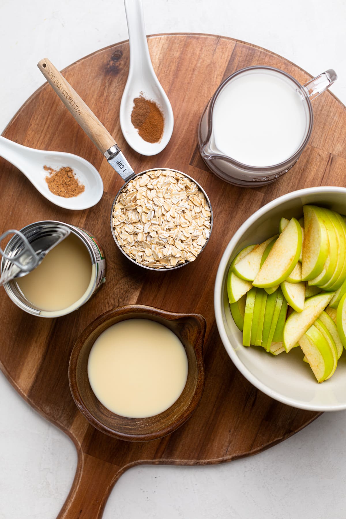 Ingredients for Apple Cinnamon Oatmeal Porridge including oats, almond milk, and condensed milk