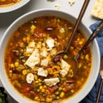 Bowl of Loaded Vegan Veggie Soup topped with a crumbled cracker