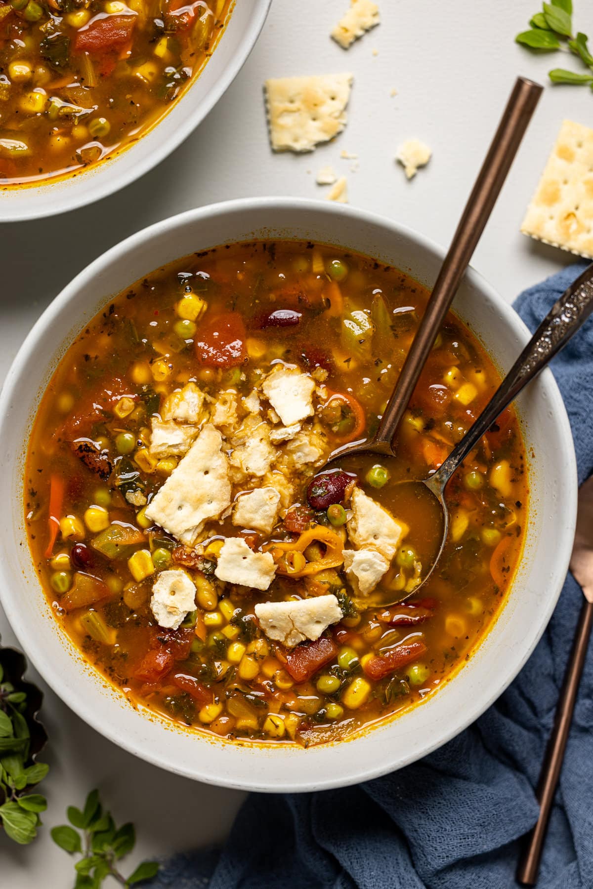 Bowl of Loaded Vegan Veggie Soup topped with a crumbled cracker