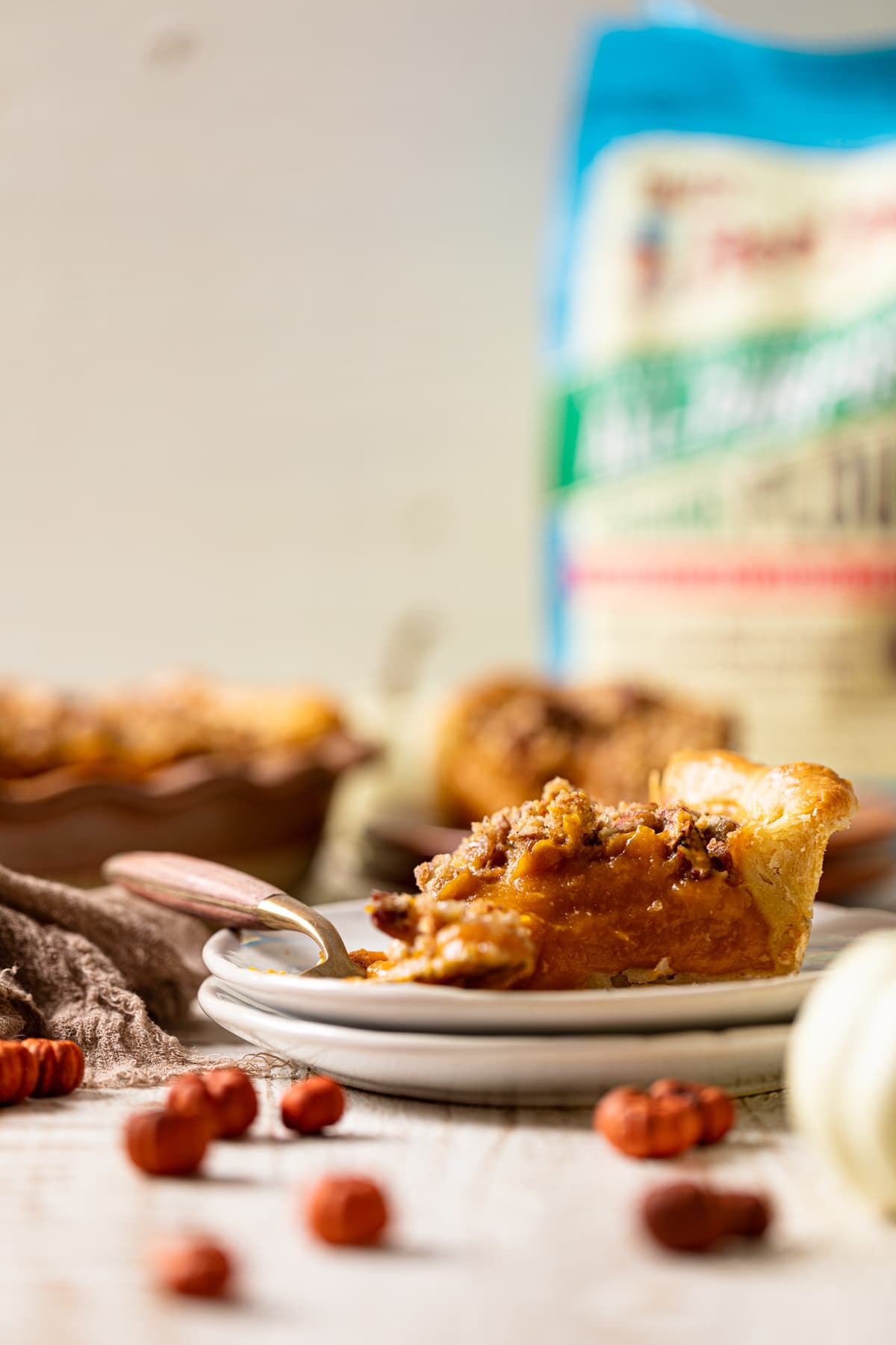 Slice of Vegan Maple Pumpkin Pie and a fork on two small, stacked plates