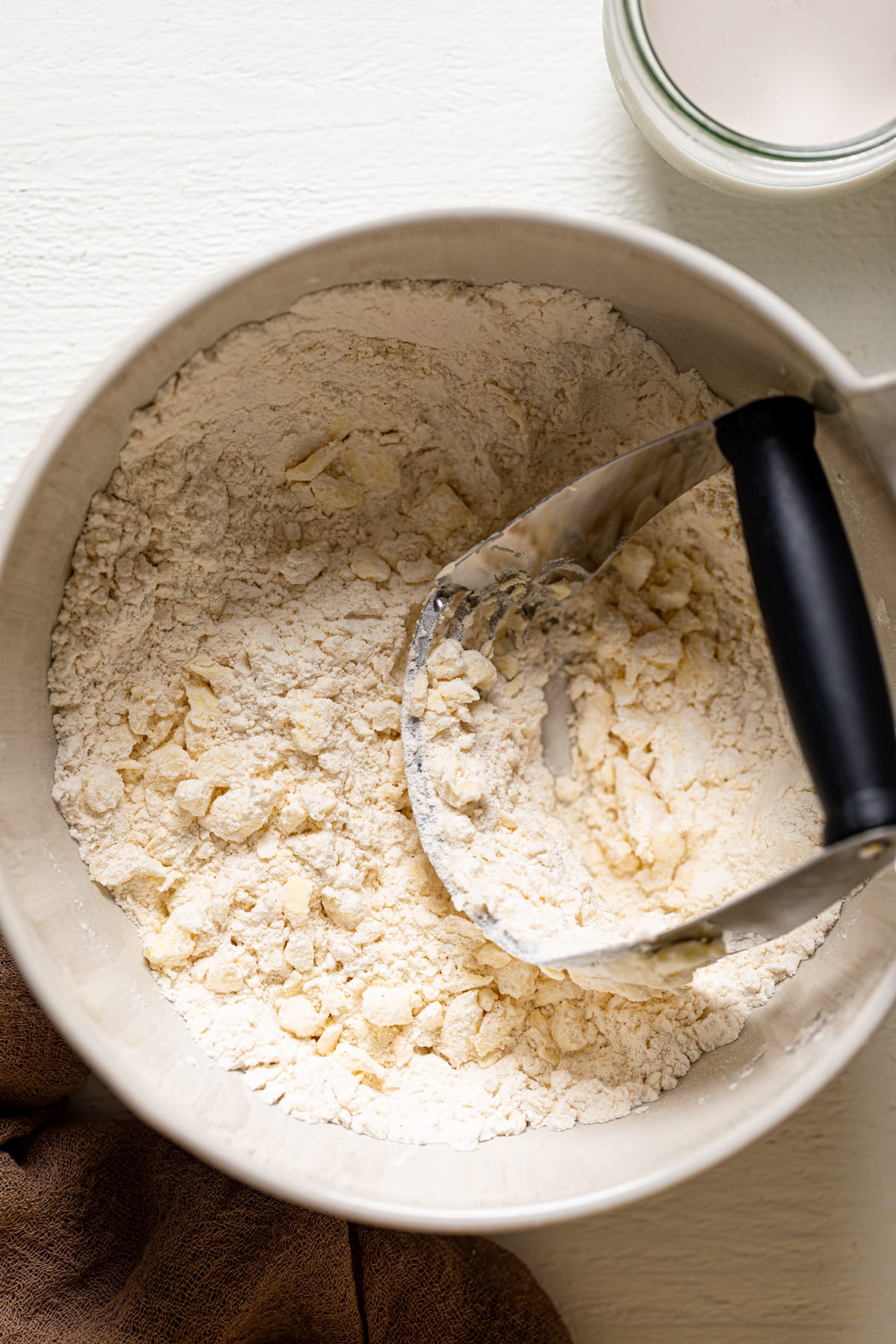 Pastry blender in a bowl of pie crust ingredients