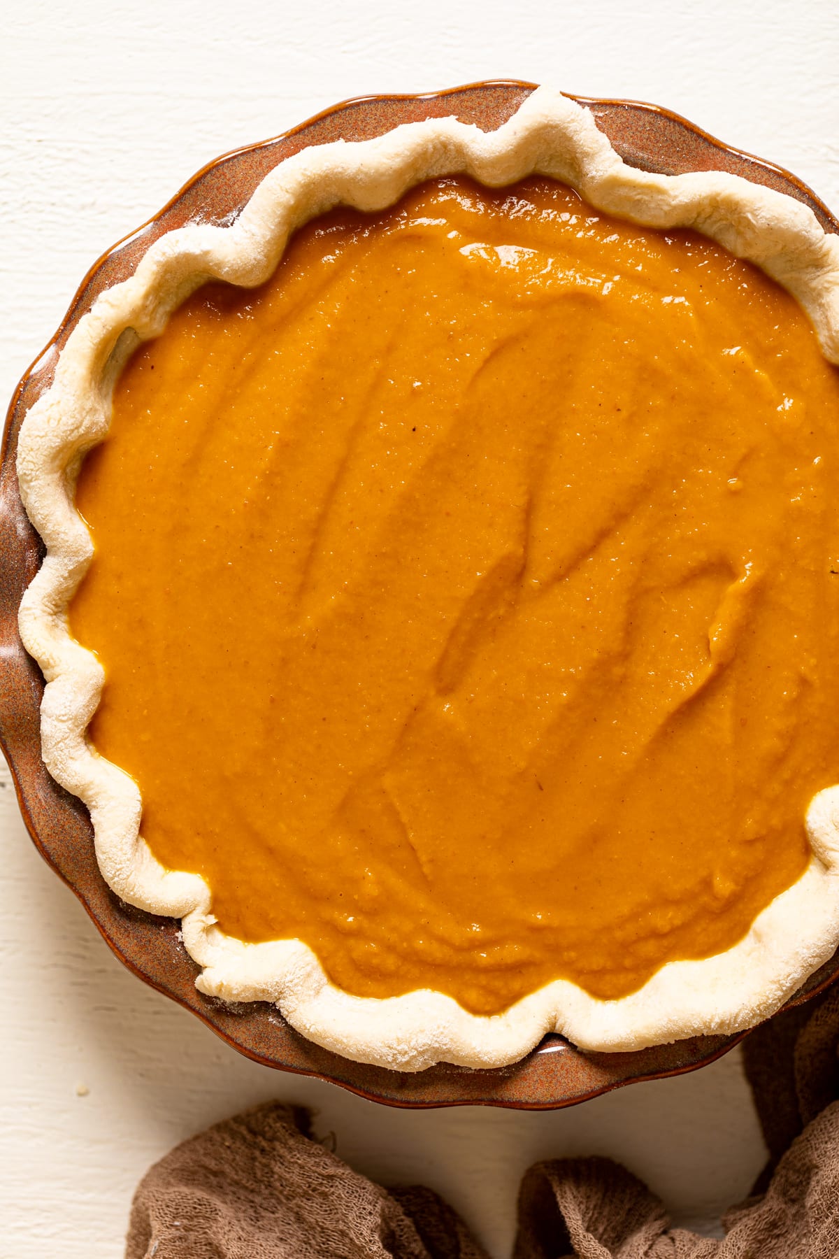 Uncooked Vegan Maple Pumpkin Pie in a brown pie pan