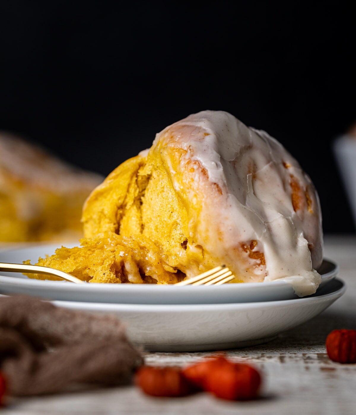 Vegan Pumpkin Cinnamon Roll on a plate with a fork.