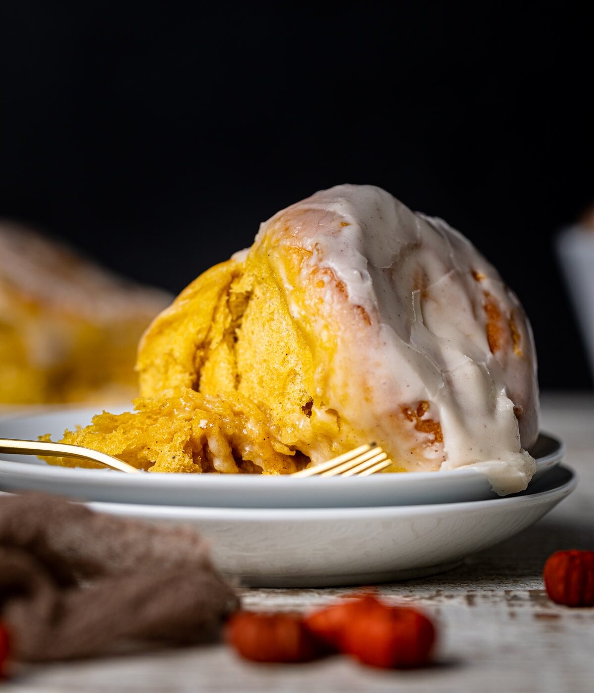 Vegan Pumpkin Cinnamon Roll on a plate with a fork.