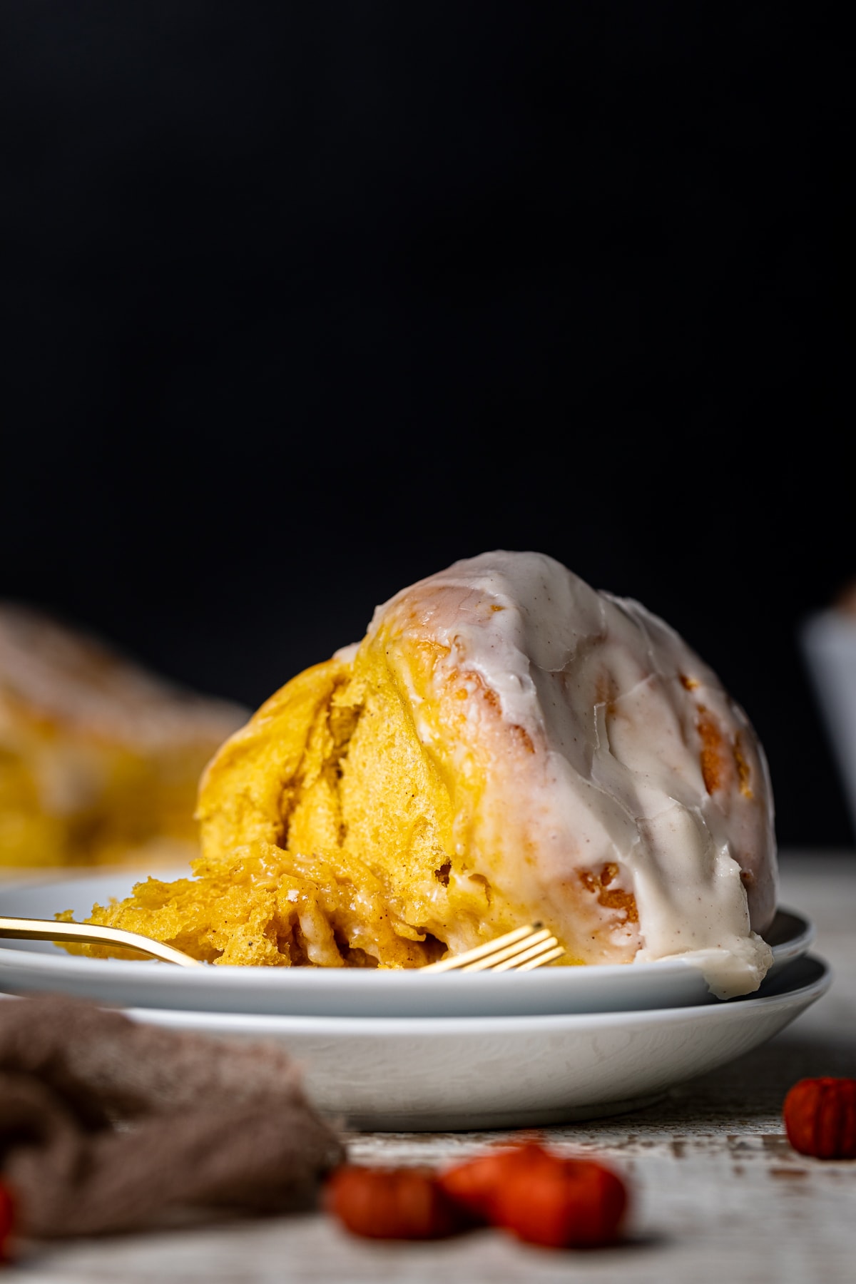 Vegan Pumpkin Cinnamon Roll on a plate with a fork.