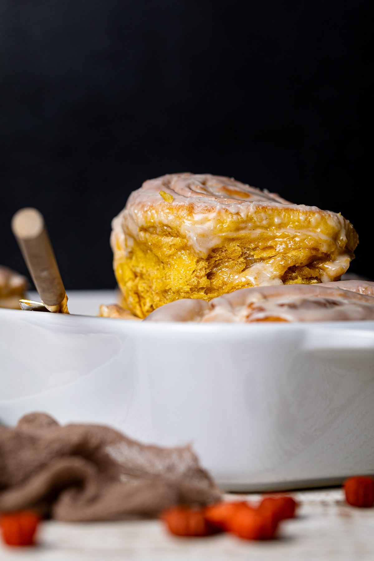 Vegan Pumpkin Cinnamon Roll being removed from a baking dish.