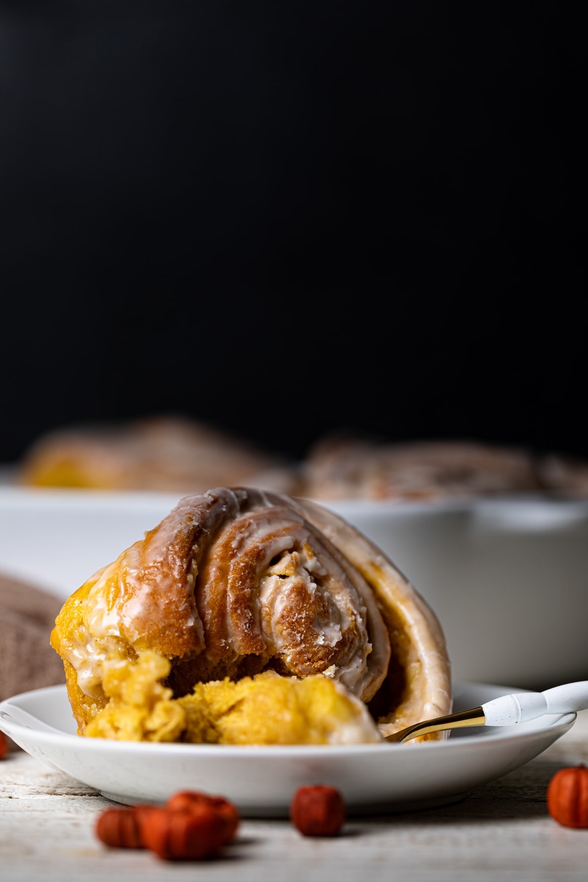 Vegan Pumpkin Cinnamon Roll on a plate with a fork.