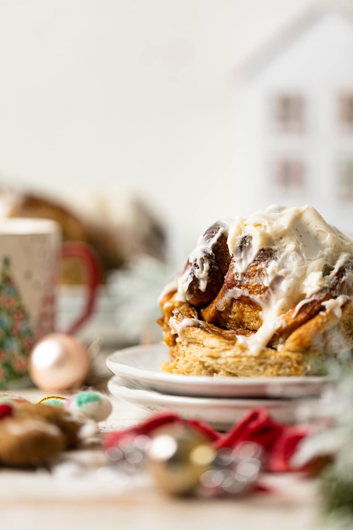 Gingerbread Cinnamon Roll with Maple Cream Cheese Frosting on two small, stacked plates