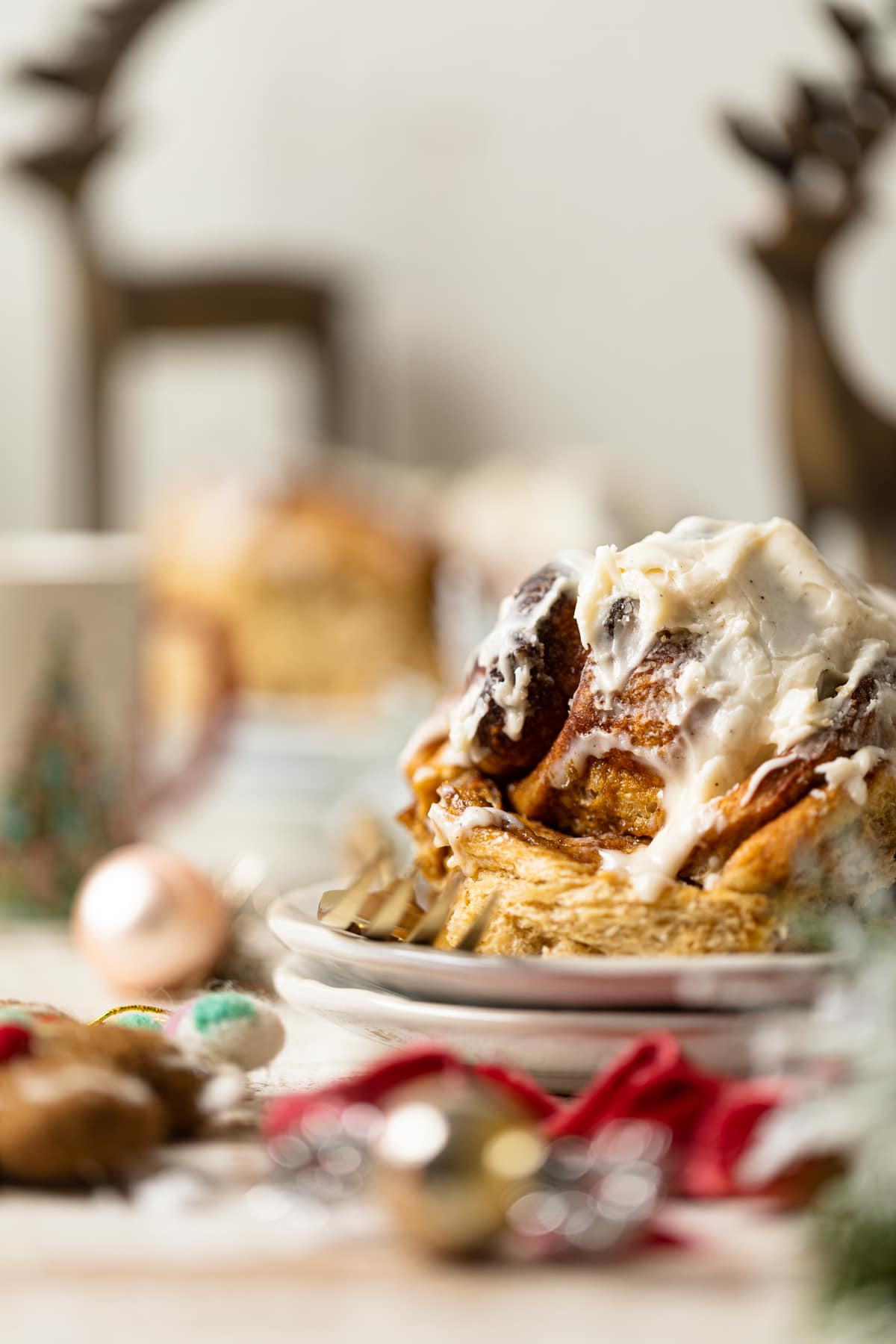 Gingerbread Cinnamon Roll with Maple Cream Cheese Frosting on two small, stacked plates