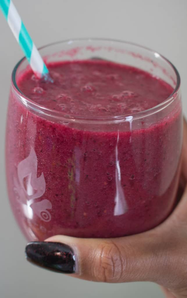 Woman holding a Sunrise Melody smoothie.