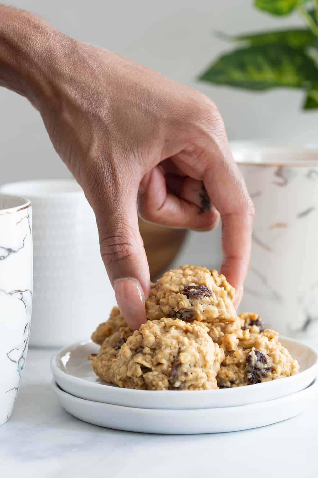 Woman grabbing a Chewy Apple Oatmeal Raisin Breakfast Cookie.