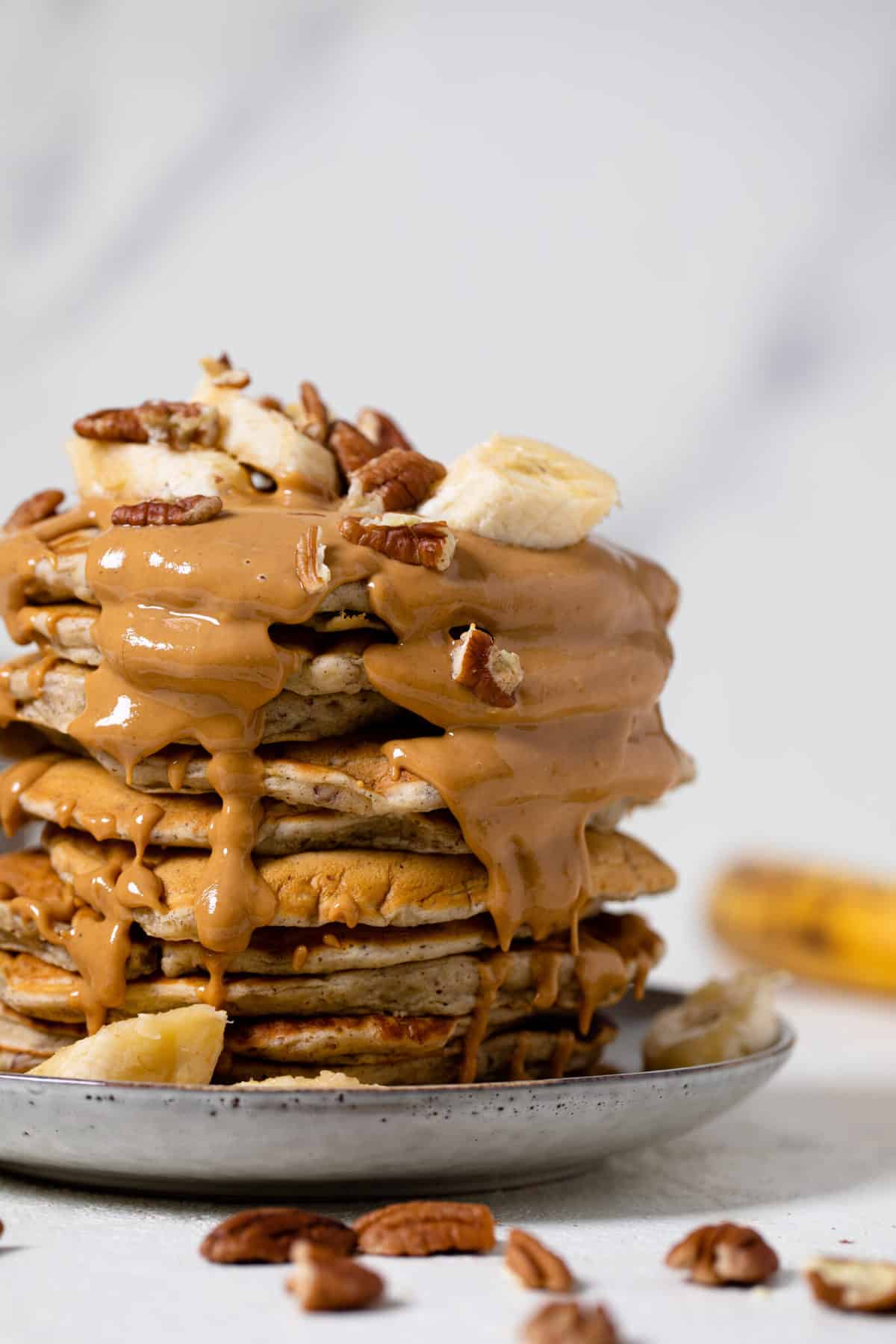 Stack of Vegan Banana Pancakes topped with Peanut Butter Sauce.