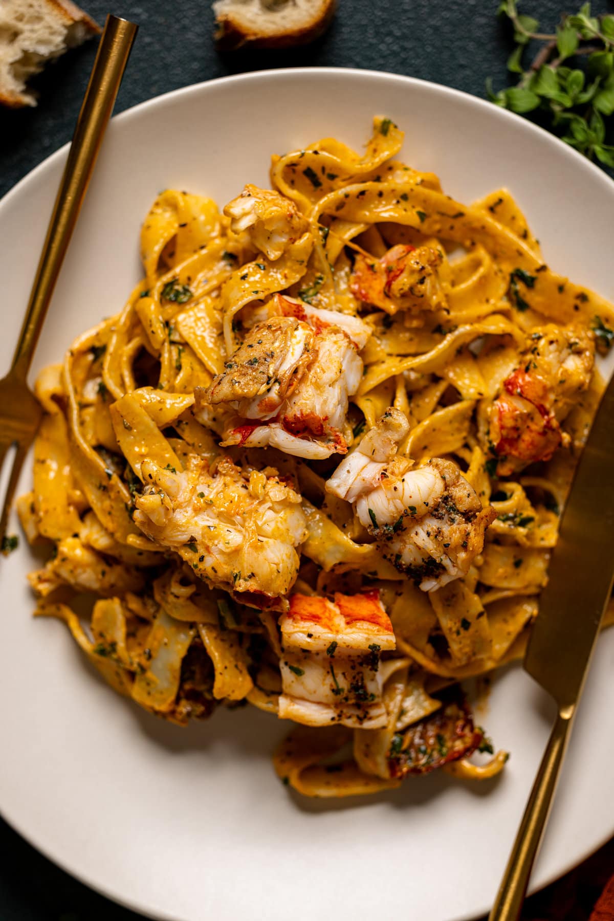 Closeup of Creamy Tuscan Lobster Pasta with a fork and a knife