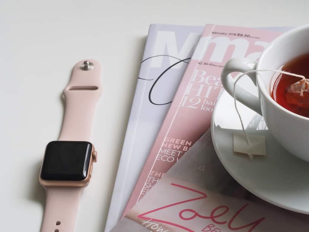 Watch with a mug of tea and stack of magazines.