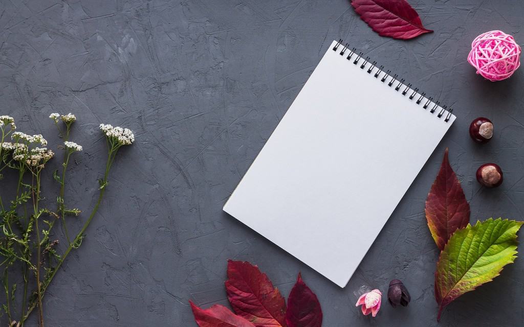 Black pad of paper with red leaves.