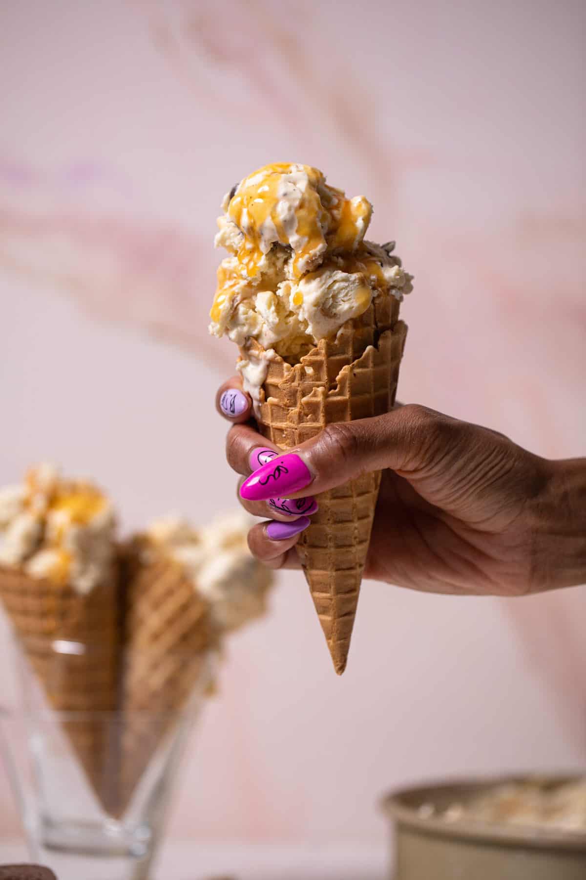 Woman holding a cone of No-Churn Caramel Cone Ice Cream.