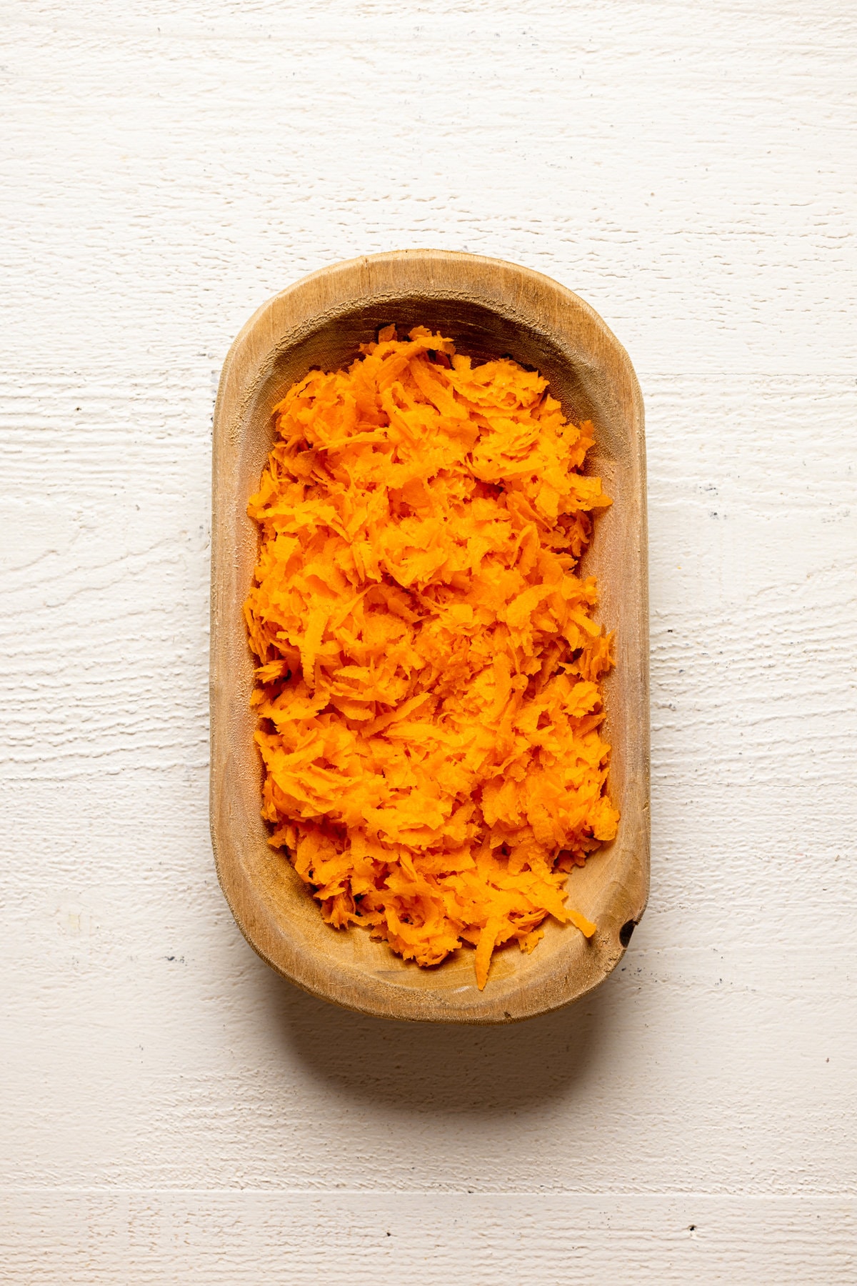 Shredded carrots in a wooden bowl