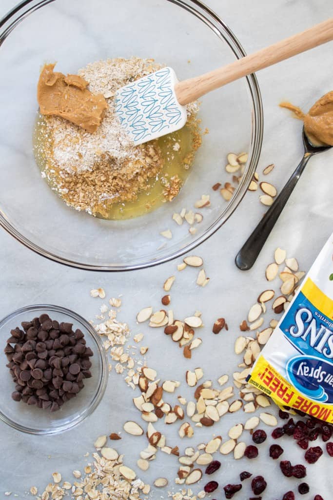 Spatula in a glass bowl of ingredients on a counter with spilled ingredients.