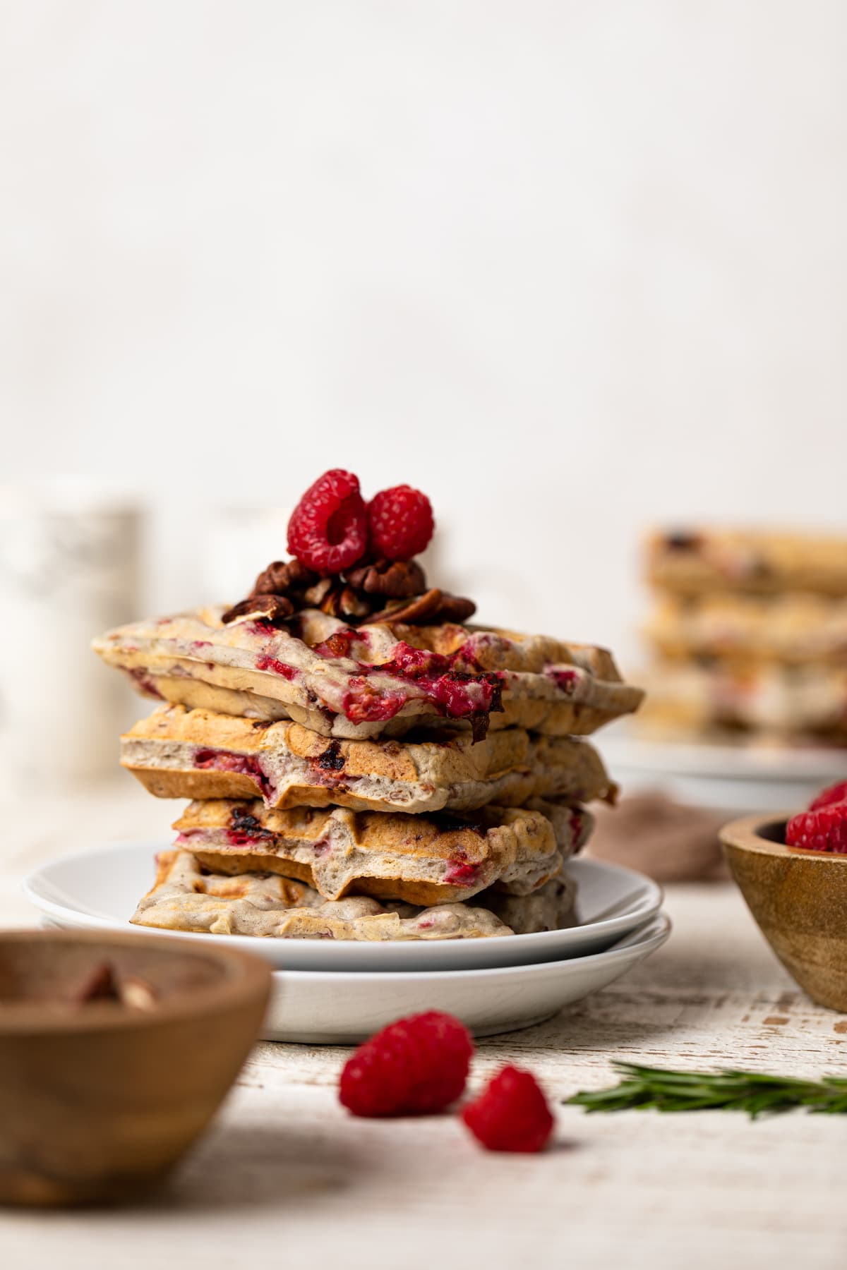 Stack of Raspberry Pecan Vegan Waffles topped with raspberries and pecans