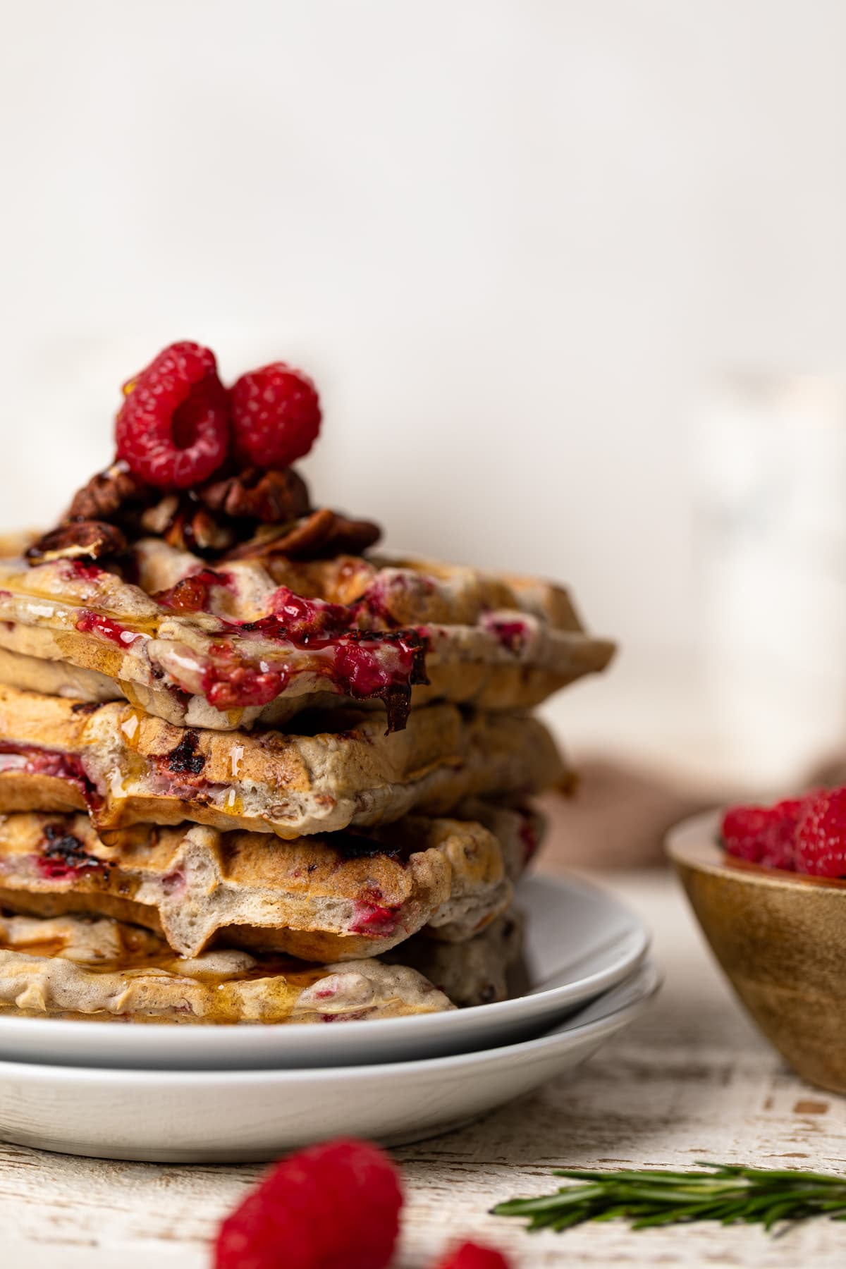 Stack of Raspberry Pecan Vegan Waffles topped with raspberries and pecans