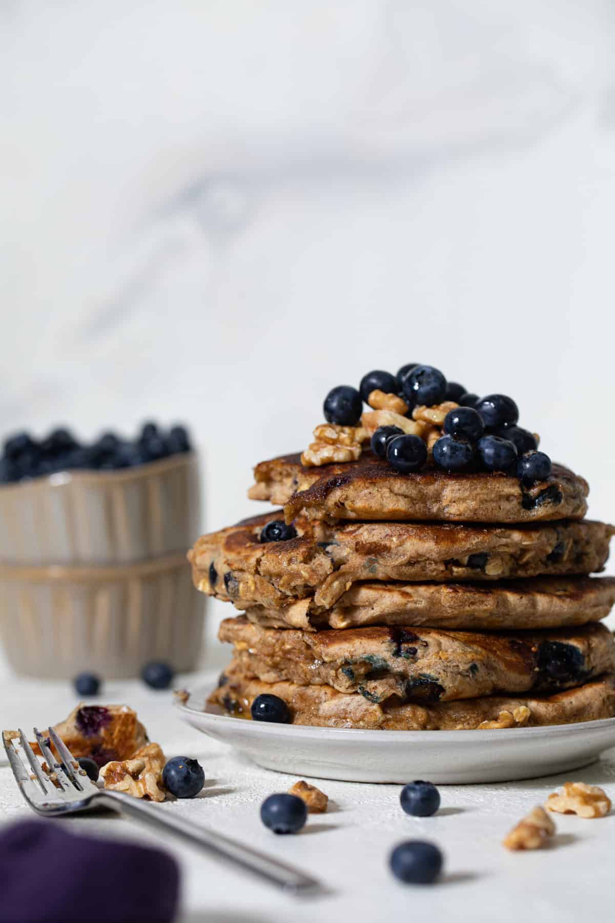 Stack of Blueberry Whole Wheat Pancakes on a white plate.
