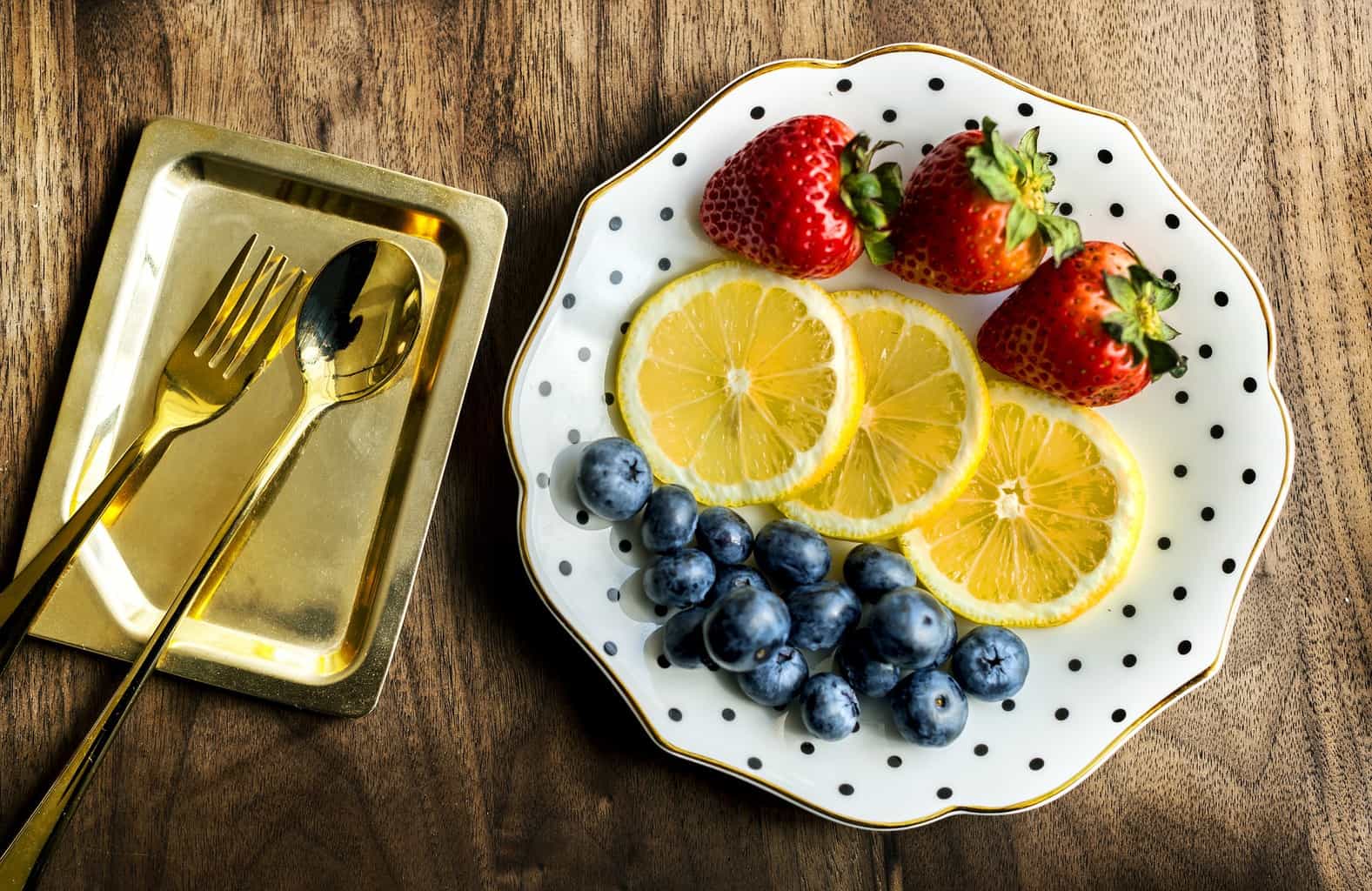Plate of fruit with silverware.