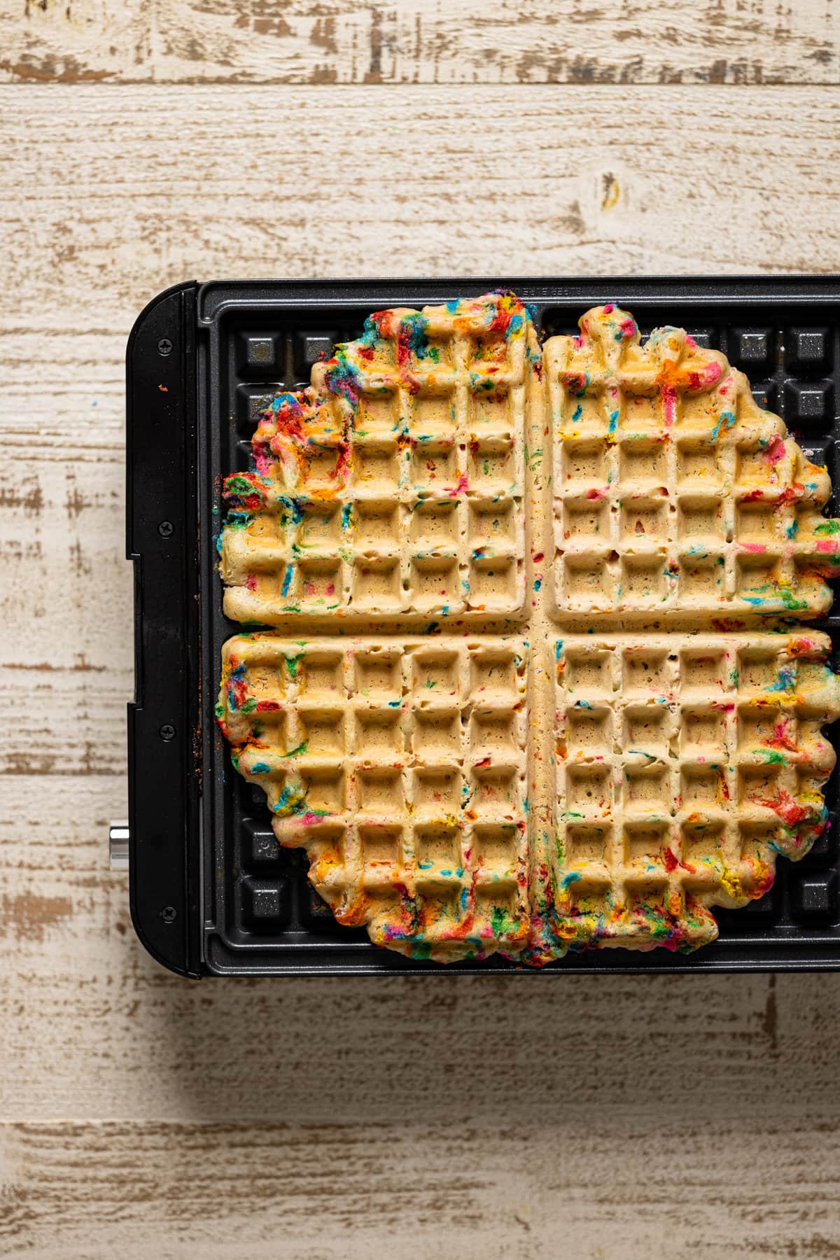 Waffle iron with cooked Funfetti Oatmeal Vegan Waffles