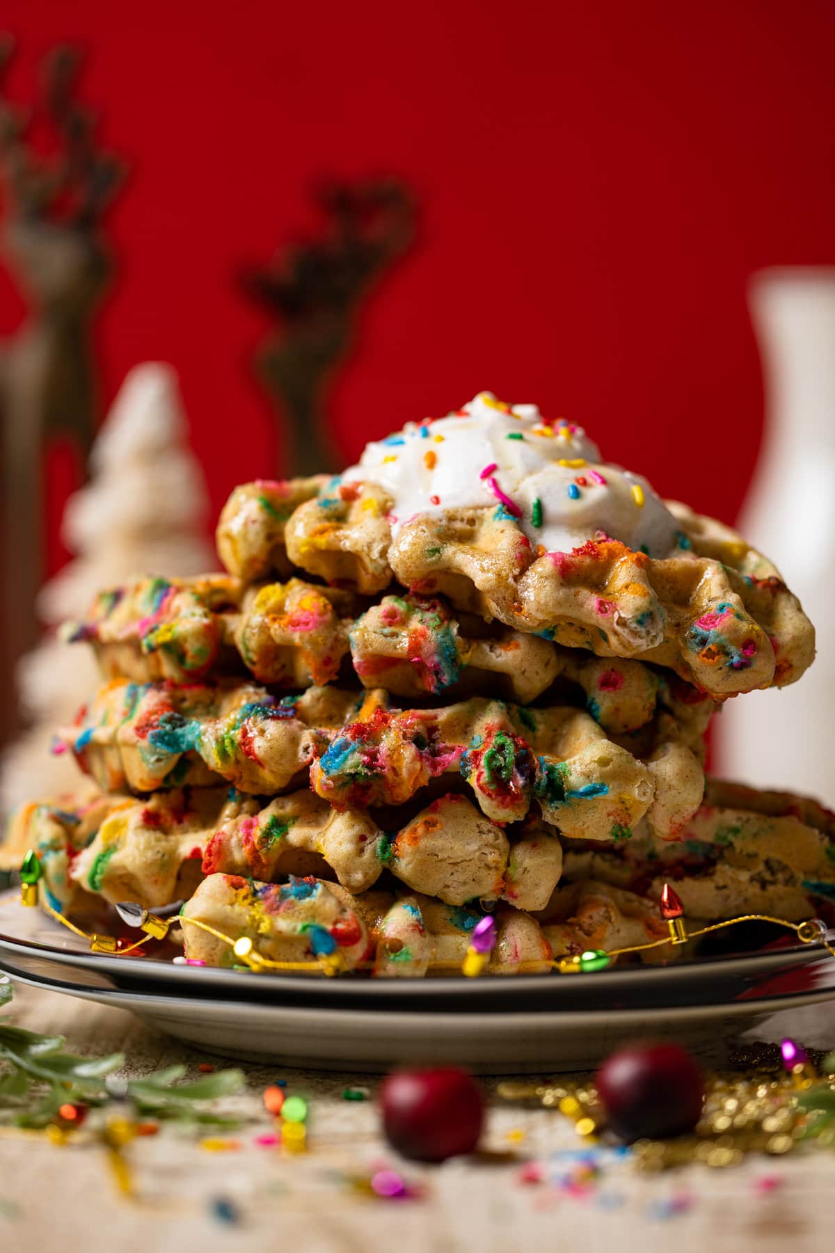 Stack of Funfetti Oatmeal Vegan Waffles circled with small Christmas lights