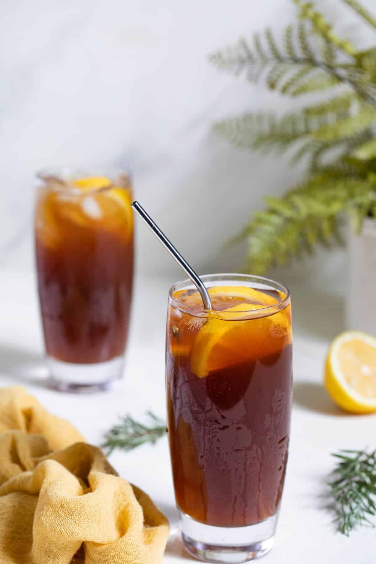 Metal straw and lemon slices in a tall glass of Traditional Southern Iced Sweet Tea.